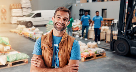 Portrait, volunteer and man with arms crossed, food distribution center and confidence. Face, people and charity workers with NGO project, kindness and social responsibility with community fundraiserの写真素材