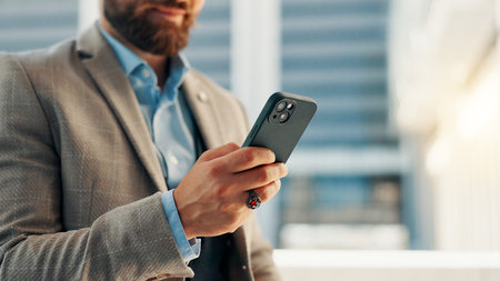 City, phone and hands of business man for networking, social media and website for contact. professional, corporate and person on smartphone for text message, email and online in town for travel.の写真素材