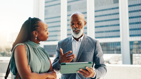 Tablet, manager and business people on rooftop in discussion for company investment with stocks. Digital technology, strategy and mentor with financial advisor for online with risk management in cityの写真素材