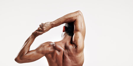 Fitness, back and man with stretching in studio for muscle wellness, body care and sports exercise on mockup space. Athlete, arm warm up and training for performance and workout on white backgroundの写真素材
