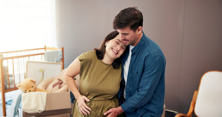 Pregnancy, couple and touching belly in home for prenatal care, maternity connection or excited for baby. People, pregnant parents and tummy affection in nursery for bonding, happy or nesting supportの写真素材