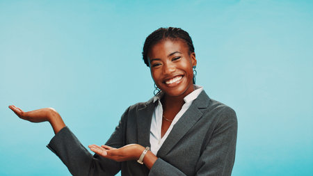 Business, presenting and black woman in studio, portrait and employee on blue background. African...