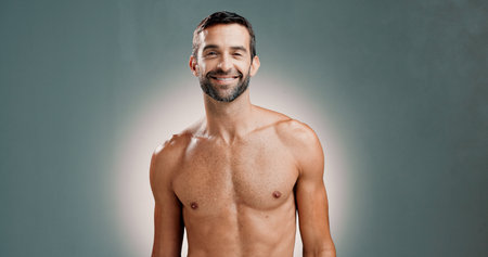 Mature man, fitness and shirtless in studio portrait with smile, pride and muscle growth by background. Person, model and happy with results, change and transformation for healthy body in Australiaの写真素材