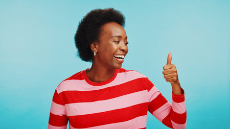 Studio, black woman and happy with thumb up for vote, review and expression of approval with smile....