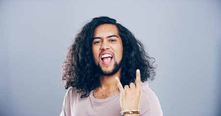 Space, wild or portrait of man with rock hand gesture in studio for expression on gray background....