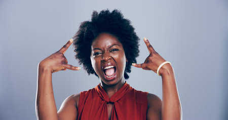 Portrait, smile or black woman in studio with rock hand gesture for expression on gray background. Culture, wild female rocker and edgy African model with devil horn sign, funky emoji or punk symbolの写真素材