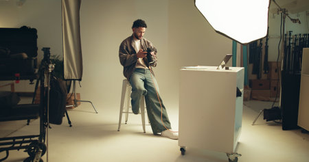 Photoshoot, studio and photographer with camera review on set for creative, branding and career. Media, production and person with photography behind the scenes for magazine cover with agencyの写真素材