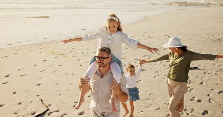 Family, holiday or walking at beach for balance, piggyback or travel in Australia with siblings, girls or love. Above, mom or dad with children at sea on fun vacation for playing, bonding or gamesの写真素材