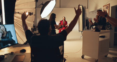People, director and applause in photoshoot studio, team celebration and production goals. Staff, model and photographer with praise for catalog achievement, beauty magazine or creative industryの写真素材