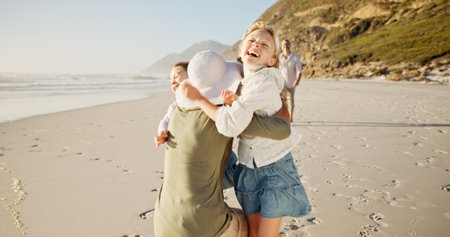 Children, smile and hug mom at beach with father, excited or bonding with love on vacation in summer. People, parents and kids on holiday, family and playful with embrace, care or happy by seaの写真素材