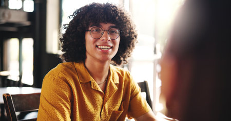 Friends, happy and man in cafe talking for conversation, discussion and social chat at coffee shop on campus. College, student and person speaking for bonding, relationship and relax on breakの写真素材