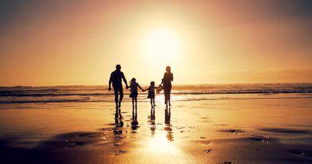Sunset, family and holding hands at sea for vacation, walking and bonding together outdoor. Back, mother and father with children at beach with mockup space, travel or summer adventure with parentsの写真素材