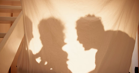 Shadow, tent and parents with kid, happiness and bonding together with joy, home and fun. Weekend break, mother and father with baby, child development and storytelling with love, cheerful and gamesの写真素材