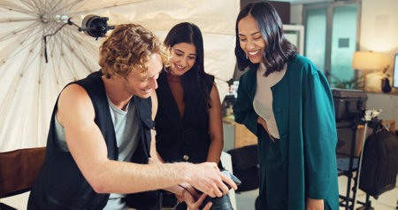 People, photographer and check camera in studio for photoshoot, photo results and production teamwork. Staff, review and tech for fashion photography, catalog and filming process of magazine industryの写真素材