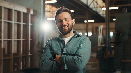 Portrait, carpenter and man with arms crossed, business and confident for career growth in warehouse. Manufacturing, entrepreneur and person with smile for startup, production and wooden furnitureの写真素材