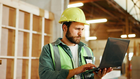 Engineer, man and carpenter with laptop for construction, manufacturing or furniture production....