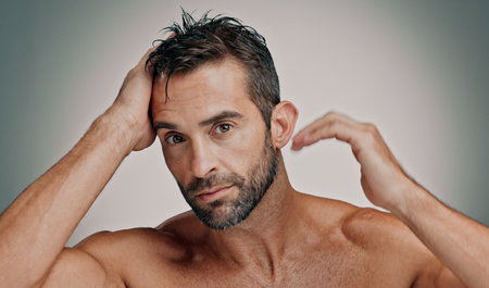Beauty, hair and cosmetics with portrait of man in studio for cleaning, salon grooming and growth. Self care, scalp and aesthetic with person on background for hairstyle, shampoo and spa treatmentの写真素材