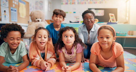 Children, group and portrait on floor in classroom, funny face and playful with diversity, education...