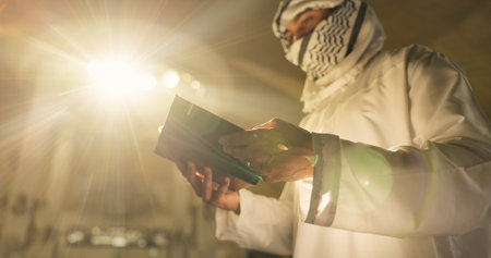 Muslim man, Quran or praying in mosque to worship for faith, below or reading to Allah in Palestine. Light, Islamic religion or learning book for spiritual guidance, dua blessing or Ramadan Kareemの写真素材