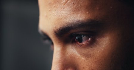 Eyes, man and serious with vision for anger, emotion or stress closeup. Determination, stare and sweat with intense person in studio for reaction to bad or upsetting news of mistake or regretの写真素材