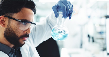 Chemical, man and scientist with beaker in laboratory for medical vaccine development or study. Liquid, glass and male chemist working on pharmaceutical research, project or observation for science.の写真素材