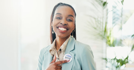 Pointing, portrait and happy woman with badge for vote, confidence or choice on button for politics. Parliament, pin and proud African politician with smile for elections, democracy or registrationの写真素材