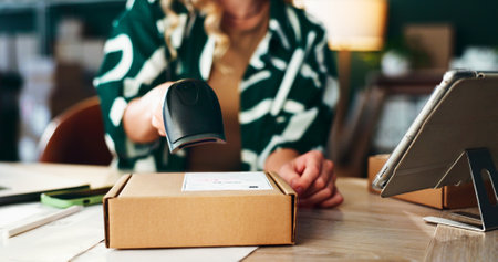 Box, logistics and scanner in hand of woman at desk for delivery or shipping tracking closeup. Barcode, retail and supply chain with courier person in depot or warehouse for ecommerce shipmentの写真素材