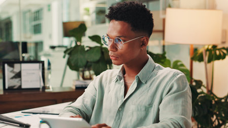 Creative, night or man on tablet in startup for social media campaign, trends and business ads. App, laptop or content strategist in agency for online review, performance or branding design researchの写真素材