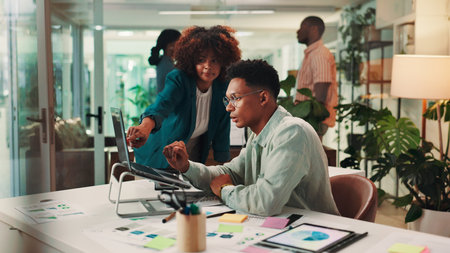 Teamwork, advice and business people in workplace, laptop and mentor with ad agency, meeting and feedback. Coaching, system training or employees in office, sales consultant or questions with helpの写真素材