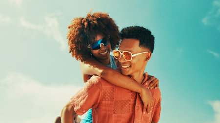 Happy, piggy back and couple on blue sky for bonding, relationship and relax together. Summer fashion, nature and man and woman outdoors for holiday, vacation and adventure on date or anniversaryの写真素材