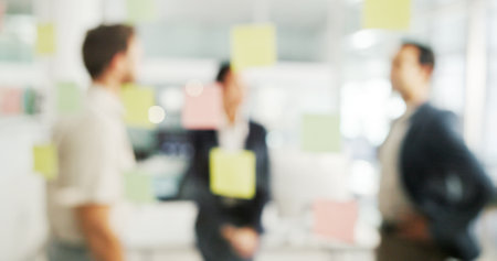 Business people, blur or meeting with glass board for schedule planning, agenda or tasks at office. Group, employees or sticky notes with reminder or sticker for team brainstorming, strategy or ideasの写真素材