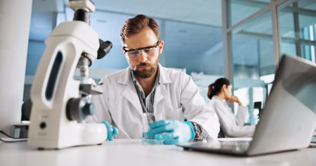Scientist, man and chemistry with laptop for research, breakthrough or medical notes analysis. Biotech, laboratory and microscope with DNA for pharmaceutical RNA study or chemical experiment projectの写真素材