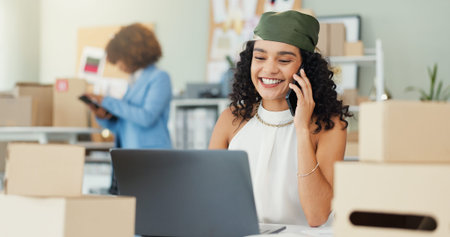 Laptop, phone call and logistics with woman and small business for delivery schedule, ecommerce and inventory. Shipping, distribution and cargo with person in office supply warehouse for stockの写真素材