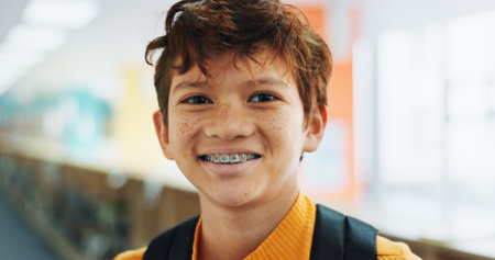 Portrait, education and boy with braces, student and confidence with smile, knowledge and learning academy. Face, happy kid and childhood with backpack, studying opportunity and campus with prideの写真素材