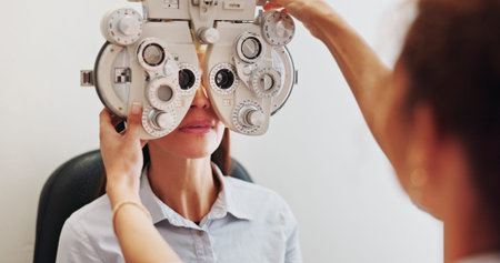Eye exam, optometry and optician with woman in clinic with phoropter for prescription lens....