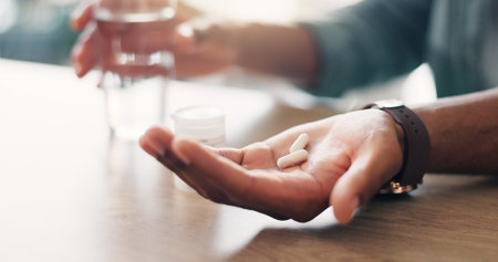 Closeup, medicine or hands of person with pills, vitamin supplements and medical prescription in home. Disease, wellness and tablets for virus, sickness with medication, flu and pharmaceutical drugsの写真素材