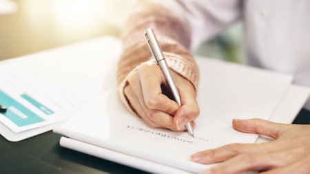 Person, scientist and hands writing with book in Japan for research, study or labratory results on desk. Closeup, medical worker or examiner taking notes for test, experiment or development at labの写真素材