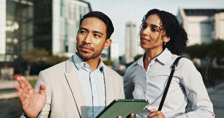 Business, people and point with tablet in city for planning, engineer team and urban development. Man, woman and explain with digital for information, project management and infrastructure expansionの写真素材