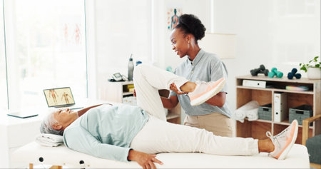 Stretching legs, senior woman and physiotherapist with help, healthcare or healing. Clinic, physical therapy and person in rehabilitation, injury recovery or exercise with medical support for fitnessの写真素材