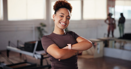 Fitness, portrait and woman with arms crossed, gym and smile in morning, personal trainer and confident. Happy, people and exercise specialist with pride for new job, athlete and girl in health clubの写真素材
