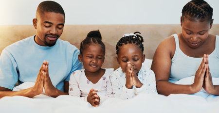 Worship, support and prayer with black family in bed for trust, spiritual and morning bonding. Love, God and christian faith with parents and children at home for religion, gratitude and catholicの写真素材