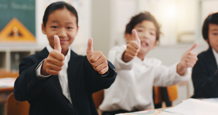 Thumbs up, Japanese children and education in classroom for support, scholarship success and learning. Studying, youth and thank you with portrait of students at school for agreement and knowledgeの写真素材
