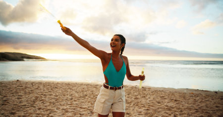Bubbles, excitement and having fun with woman on beach in summer for holiday or vacation. Energy, freedom and smile of happy person on sand of tropical island paradise for adventure or travelの写真素材
