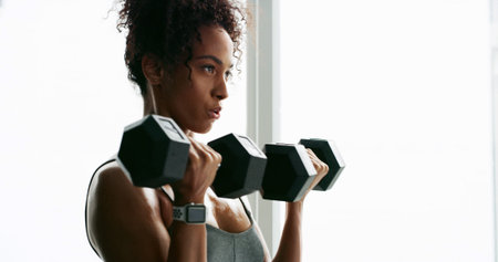 Dumbbells, exercise and weightlifting with woman in home gym for strength training or workout....