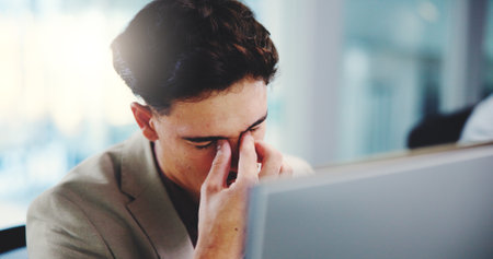 Business, tired and man on computer with stress, pressure or exhausted accountant on deadline. Migraine, fatigue and worker in office with headache, burnout and financial mistake or crisis with auditの写真素材