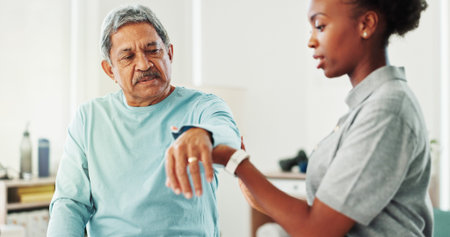 Physiotherapist, woman and senior man with arm, assessment and support for recovery at clinic....