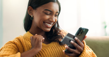 Excited, woman or phone with credit card rewards for financial bonus, savings or investment payment. Fintech notification, smile or happy Indian girl winning competition on bank app or mobile in homeの写真素材