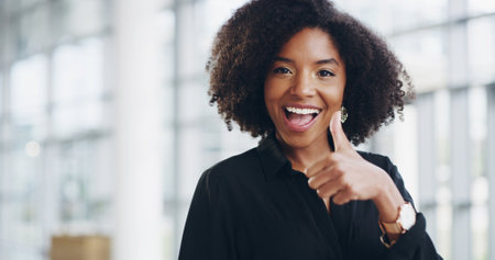 Thumbs up, portrait and thank you with business woman in office for success deal approval and space. Support, feedback and agreement sign with African person for smile, vote and review guaranteeの写真素材