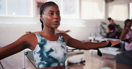 Breathing, fitness and pilates with woman in class for improvement, training or workout routine. Concentration, exercise and reformer with person on machine in studio for challenge or performanceの写真素材