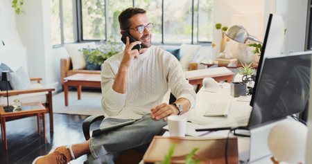 Remote work, computer and man with phone call for discussion, networking and listen to news source. Freelancer, journalist and mobile at home for article questions, information and facts verificationの写真素材
